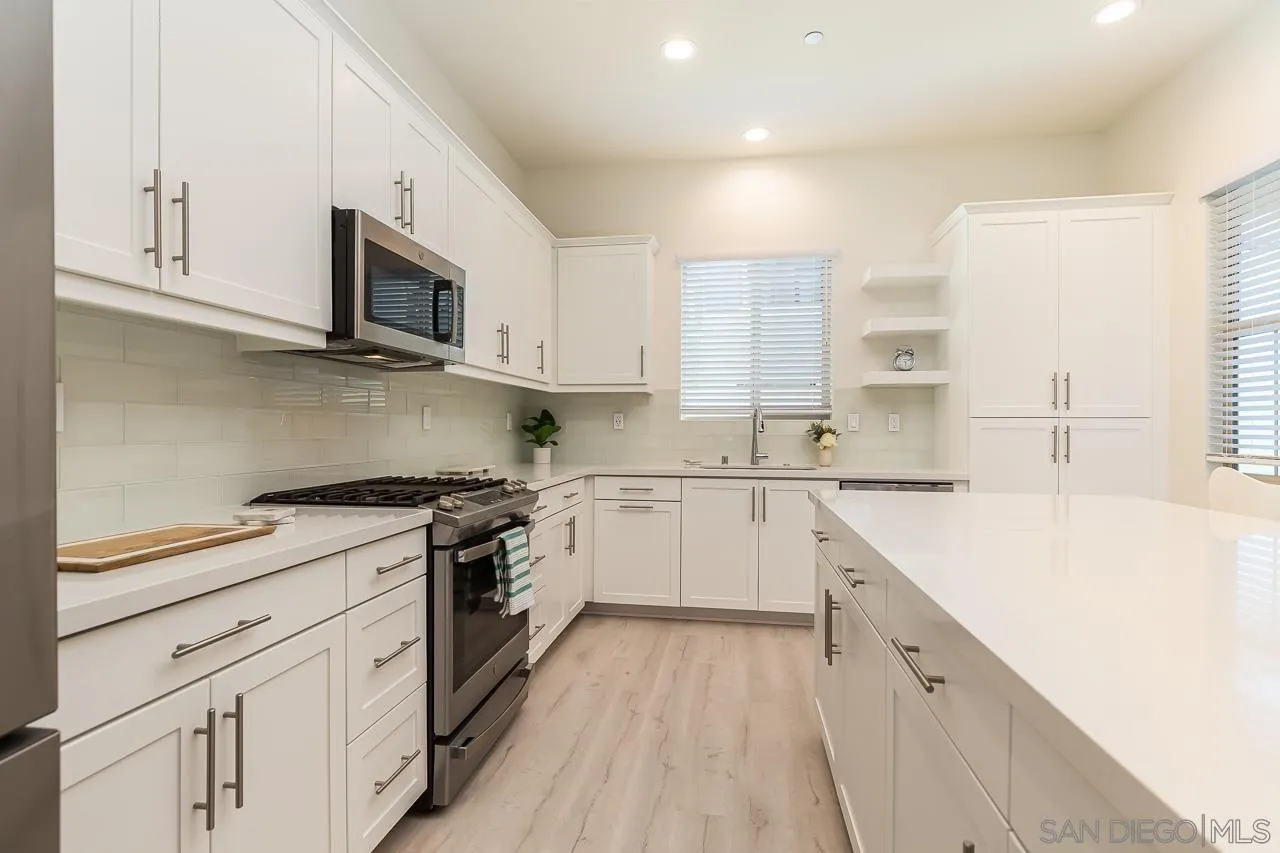 597 Townsend Way San Marcos, CA 92078 - Photo 10 of 30 a kitchen with granite countertop white cabinets and white appliances