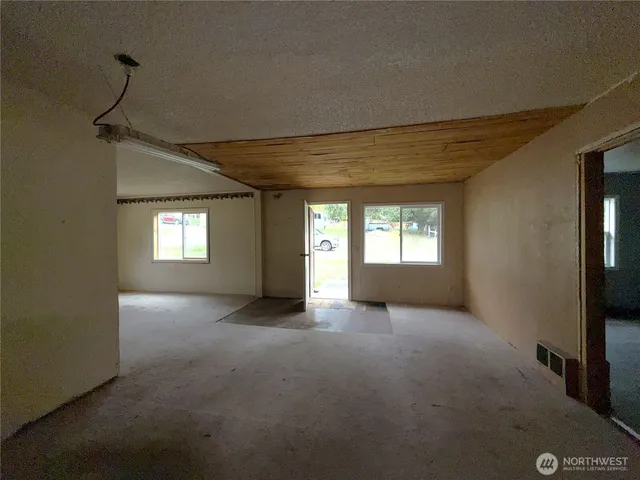 a view of a big room with windows and chandelier fan