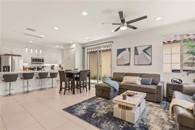 a living room with lots of furniture and a view of kitchen