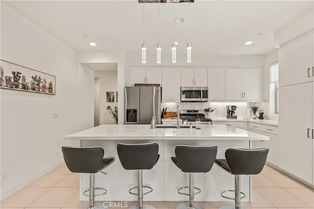 a kitchen with stainless steel appliances kitchen island granite countertop a dining table and chairs