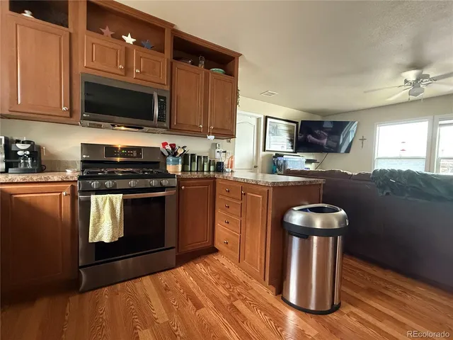 a kitchen with stainless steel appliances kitchen island granite countertop a stove a sink and a microwave