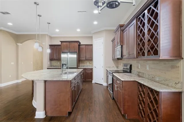 a kitchen with stainless steel appliances granite countertop a sink a stove and a refrigerator