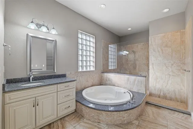 a bathroom with a granite countertop sink toilet a mirror a vanity and shower