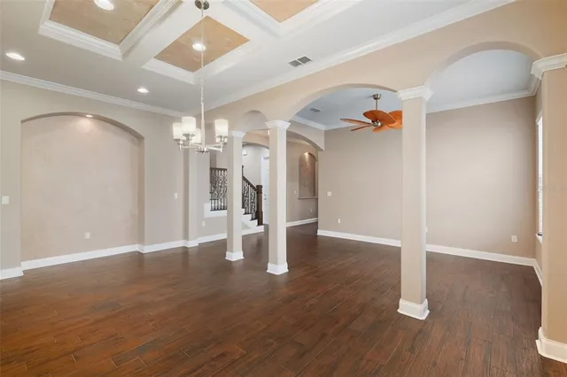 a view of a room with wooden floor and a ceiling fan