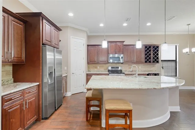a large kitchen with kitchen island a sink stove and refrigerator