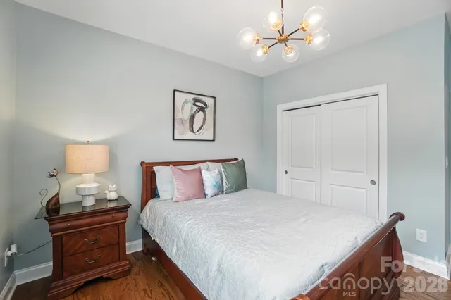 a bedroom with a bed and a lamp on dresser