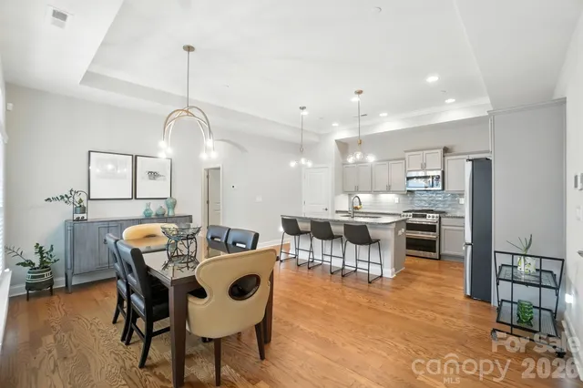 a dining room with furniture a chandelier and wooden floor
