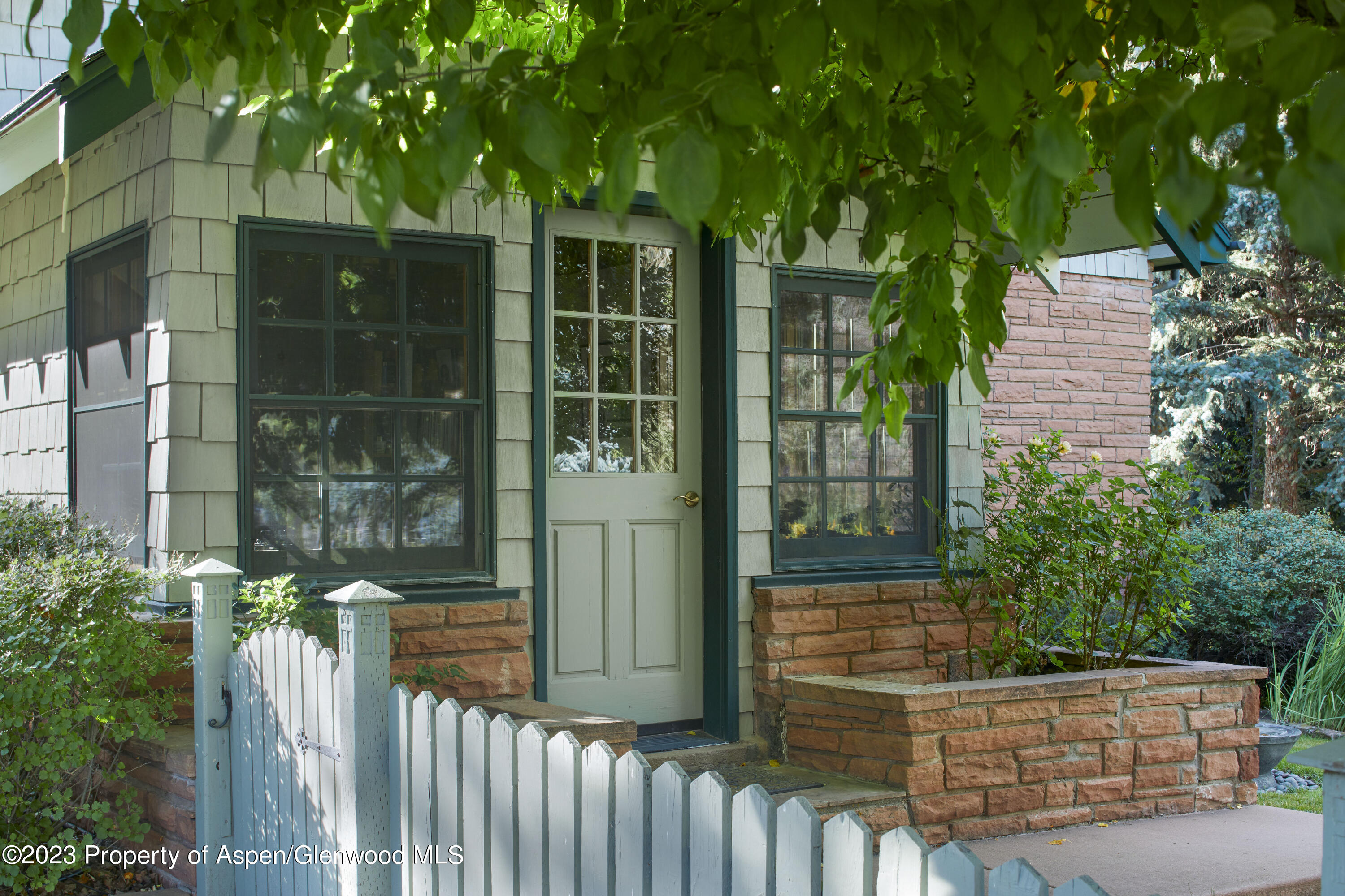 135 Riverside Drive Basalt, CO 81621 - Photo 2 of 18 a small yard with a large tree and wooden fence