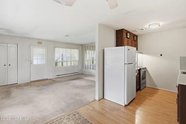 a view of a kitchen with refrigerator and wooden floor