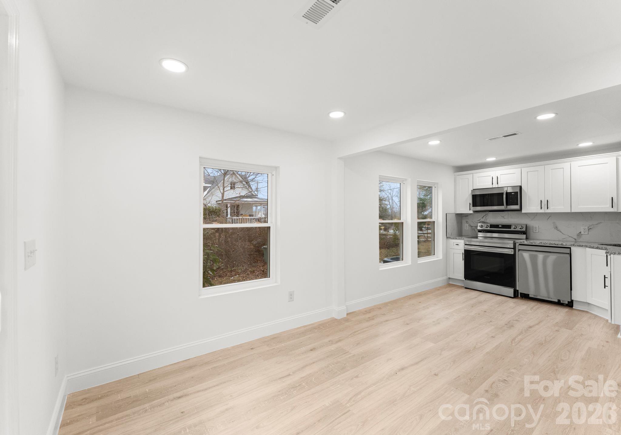 1413 Modena Street Gastonia, NC 28054 - Photo 22 of 27 a large kitchen with stainless steel appliances granite countertop a stove and a refrigerator