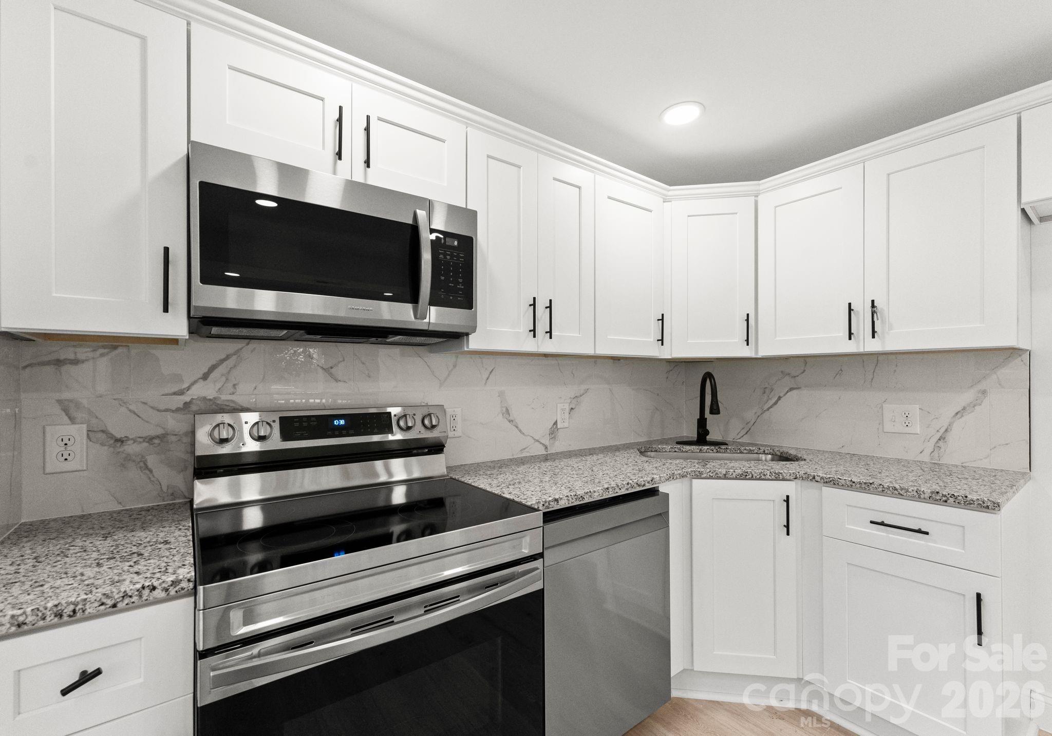 1413 Modena Street Gastonia, NC 28054 - Photo 24 of 27 a kitchen with stainless steel appliances granite countertop white cabinets granite counter tops and a wooden floors
