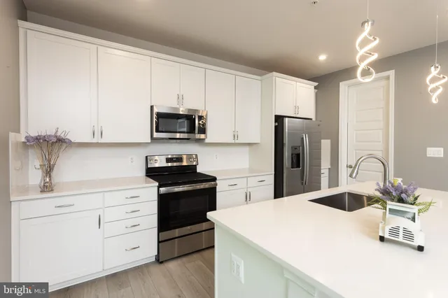 a kitchen with appliances a sink and a refrigerator