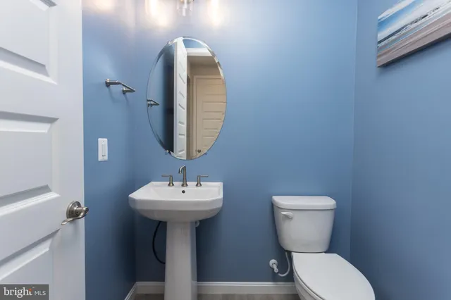 a bathroom with a sink toilet and a mirror