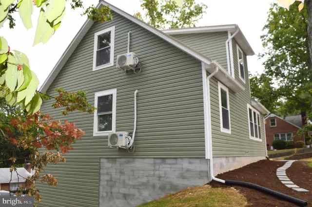 a backyard of a house with large trees and outdoor seating