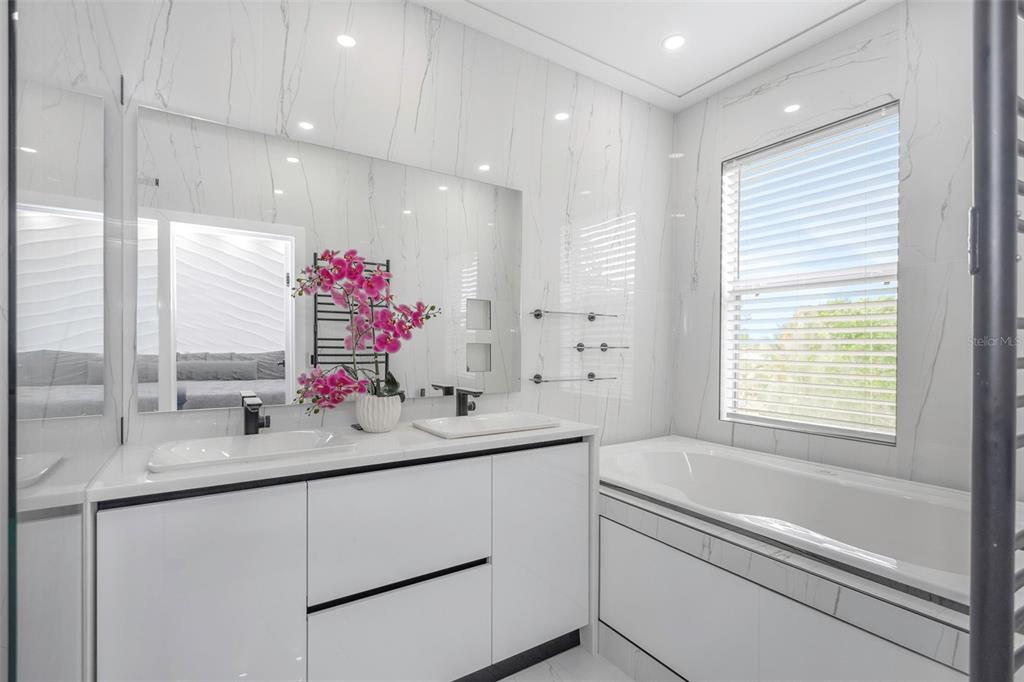 7130 102nd Lane Seminole, FL 33772 - Photo 16 of 31 a bathroom with a sink vanity tub and a mirror