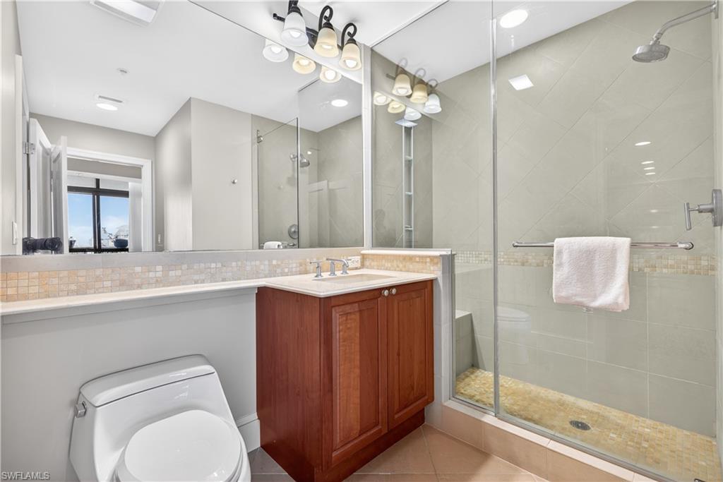 9115 Strada Place, Unit 5504 Naples, FL 34108 - Photo 13 of 22 a bathroom with a sink a toilet and shower