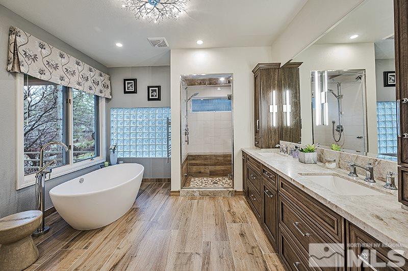 4278 Bitteroot Road Reno, NV 89519 - Photo 18 of 29 a spacious bathroom with a double vanity sink a large mirror a bathtub and a shower
