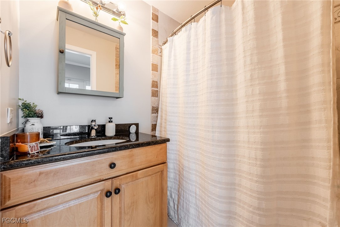 8327 Riviera Avenue Fort Myers, FL 33919 - Photo 37 of 49 a bathroom with a granite countertop sink and a mirror