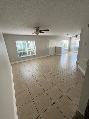 a view of empty room with windows and ceiling fan