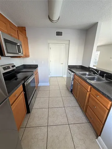 a kitchen with a sink a stove and a microwave