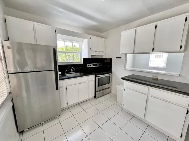 a kitchen with granite countertop white cabinets and white appliances