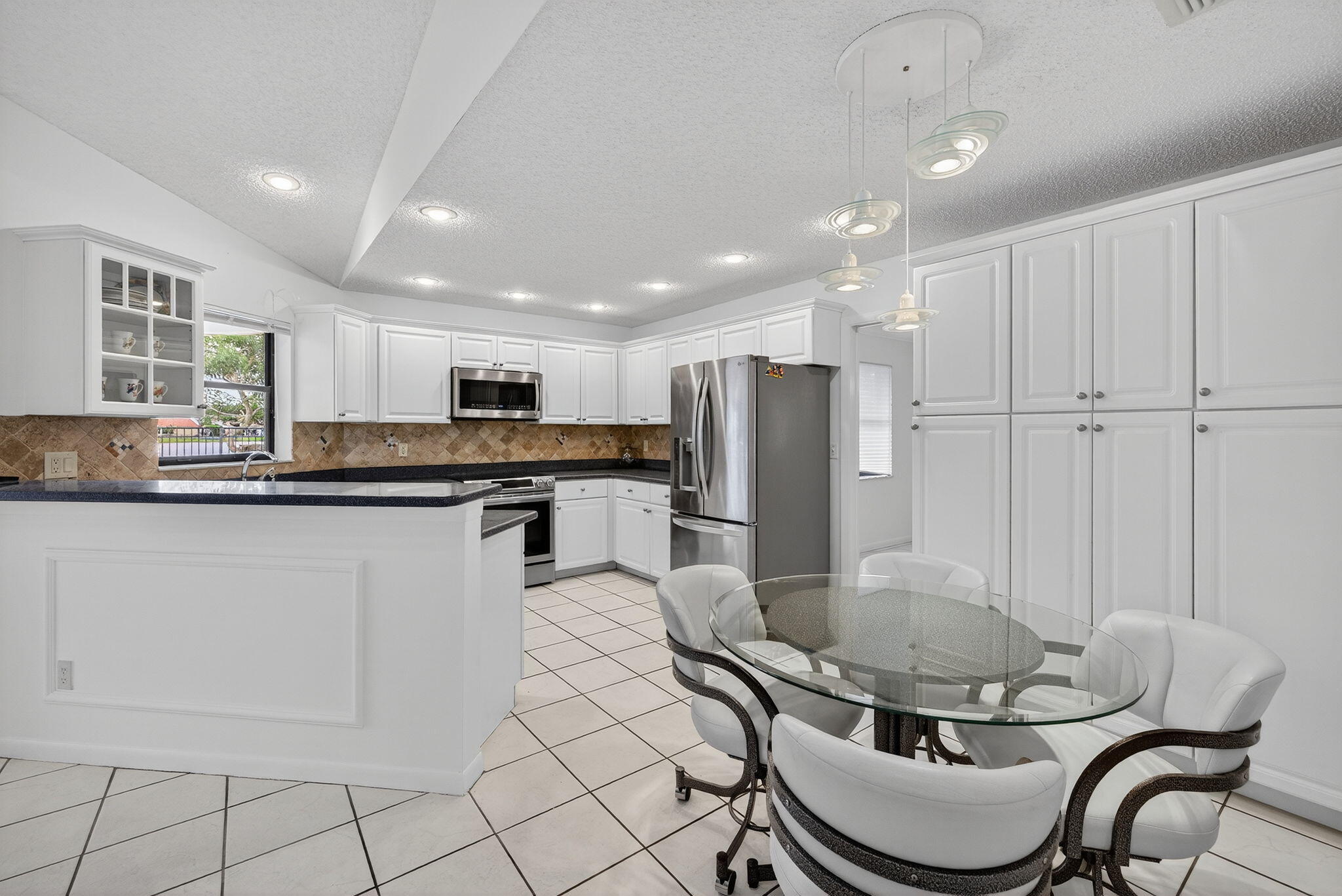 3140 Old Orchard Road Davie, FL 33328 - Photo 12 of 41 a kitchen with stainless steel appliances granite countertop a stove a sink a refrigerator and a refrigerator