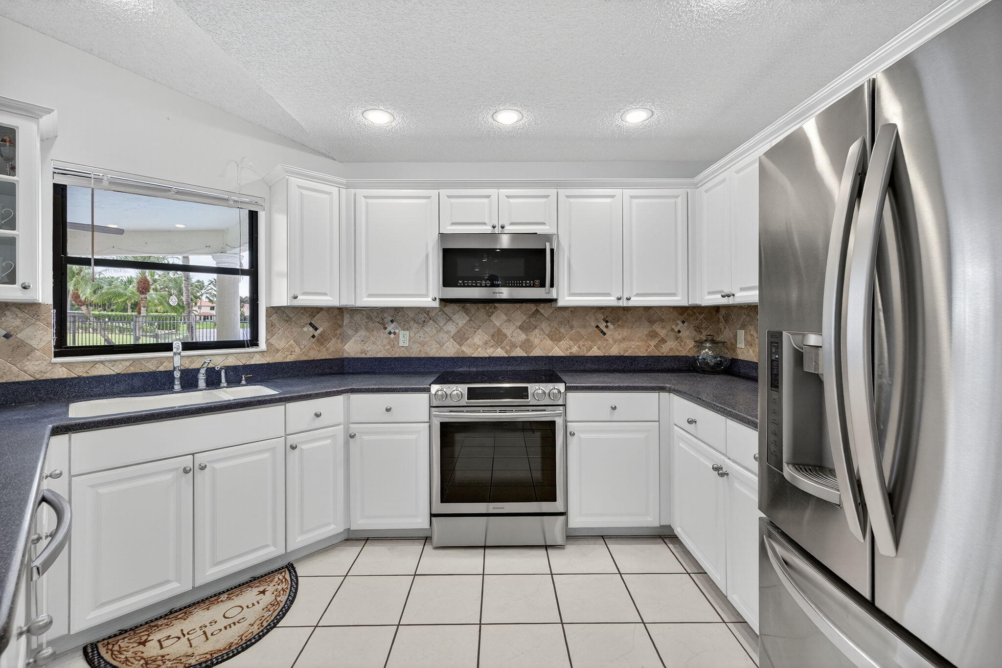 3140 Old Orchard Road Davie, FL 33328 - Photo 4 of 41 a kitchen with stainless steel appliances granite countertop a stove a sink and a refrigerator