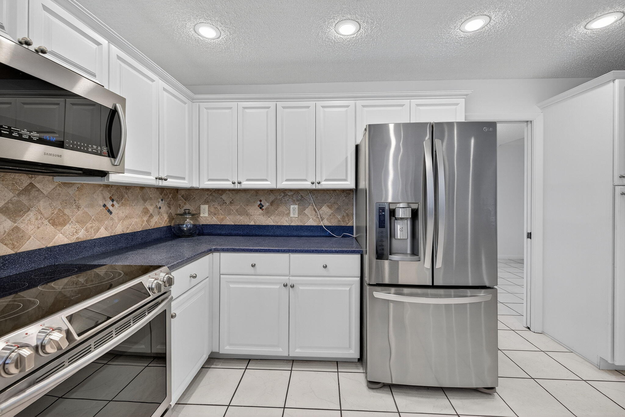 3140 Old Orchard Road Davie, FL 33328 - Photo 6 of 41 a kitchen with stainless steel appliances granite countertop a refrigerator and a stove top oven