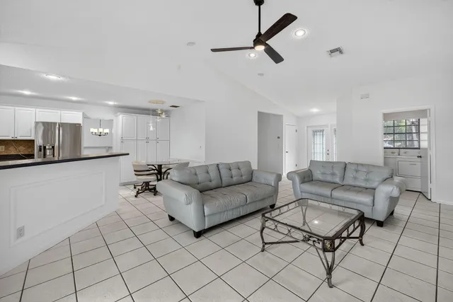 a living room with furniture and a view of kitchen