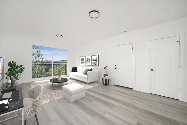 a view of a livingroom with furniture wooden floor and windows