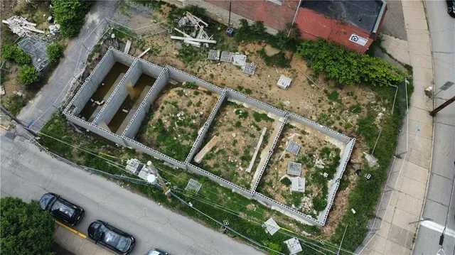 an aerial view of a residential houses with outdoor space and street view