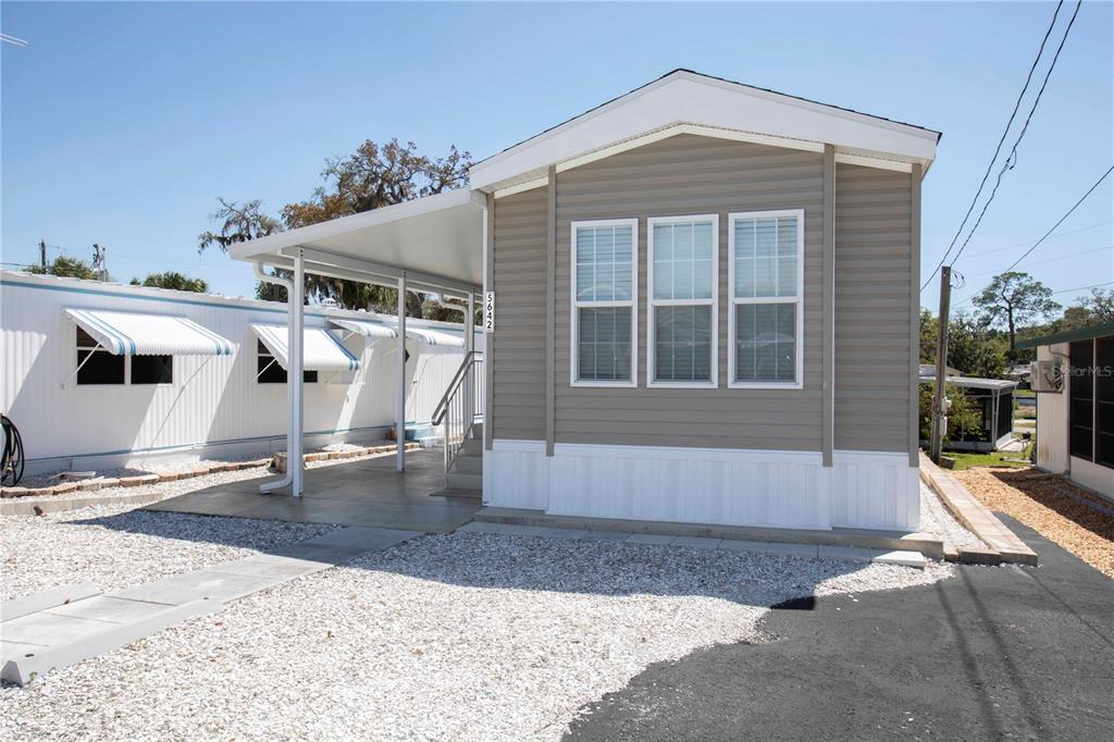 5642 Oak Ridge Avenue New Port Richey, FL 34652 - Photo 2 of 44 a front view of a house with a yard