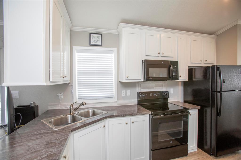 5642 Oak Ridge Avenue New Port Richey, FL 34652 - Photo 10 of 44 a kitchen with granite countertop a sink stove and refrigerator