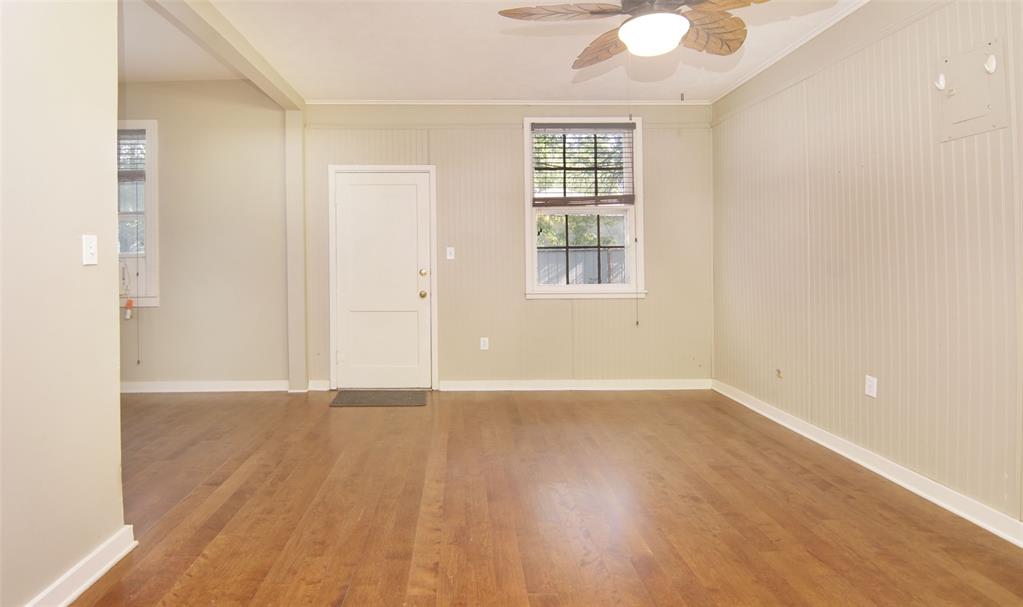 730 Indiana Street Graham, TX 76450 - Photo 17 of 25 an empty room with wooden floor and windows