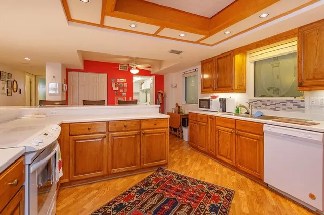 a large kitchen with stainless steel appliances granite countertop a sink and cabinets
