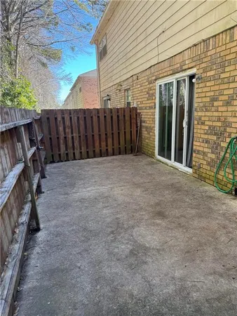 a view of backyard with wooden fence and a large tree