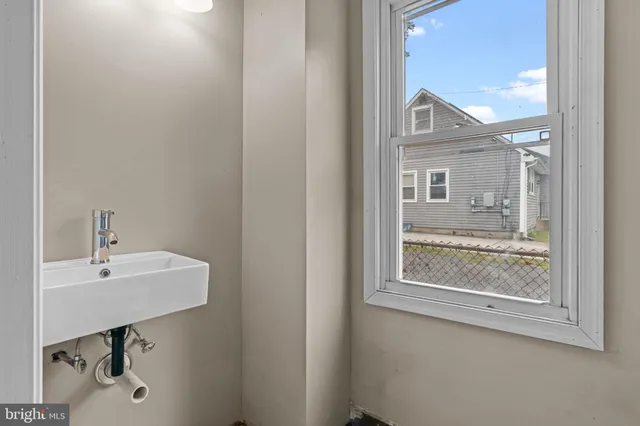 a bathroom with a sink a mirror and a window