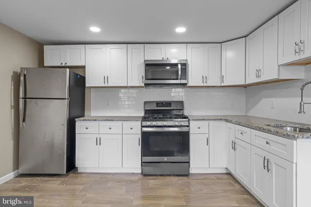 a kitchen with white cabinets and stainless steel appliances
