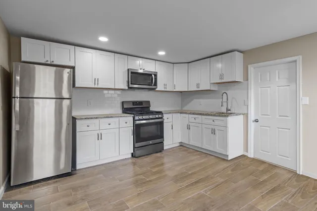 a kitchen with white cabinets and stainless steel appliances