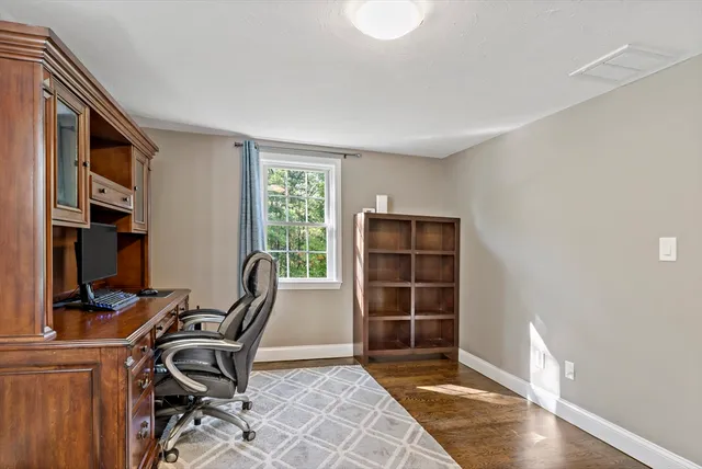 a view of a workspace with furniture and a window