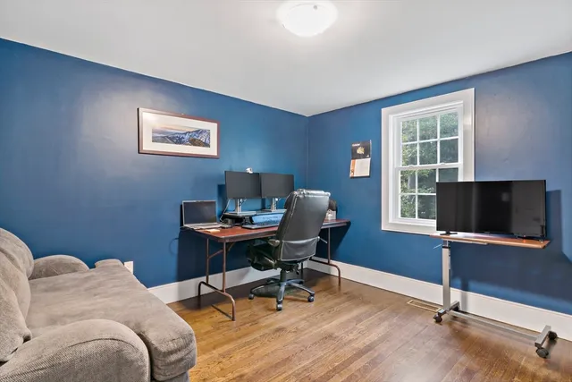 a view of a workspace with furniture and a window