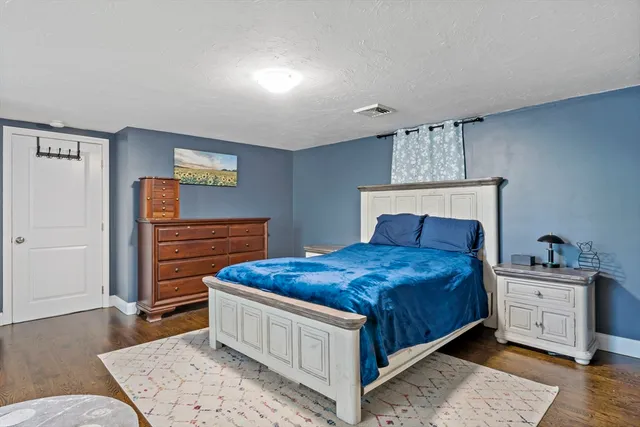 a bedroom with a bed and a dresser in it