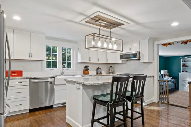 a kitchen with cabinets a sink dishwasher a dining table and chairs