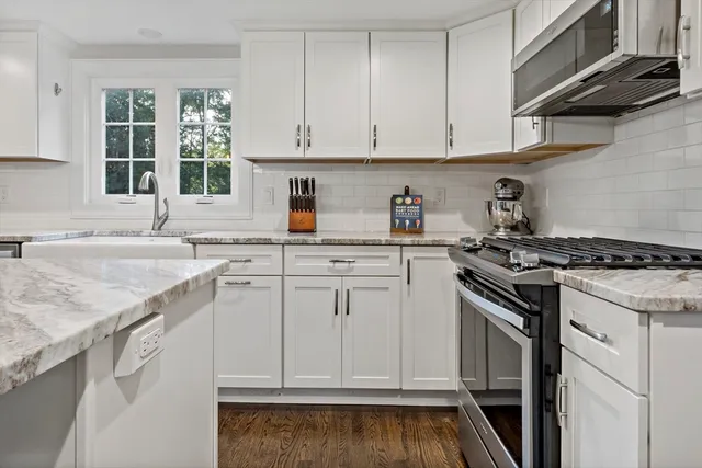 a kitchen with granite countertop cabinets stainless steel appliances and a sink