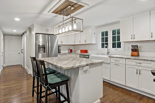 a kitchen with a table chairs refrigerator and microwave