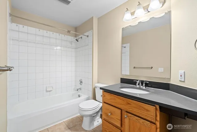 a bathroom with a sink a toilet a mirror a bathtub and shower