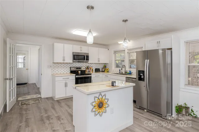 a kitchen with a refrigerator a stove top oven a sink and cabinets