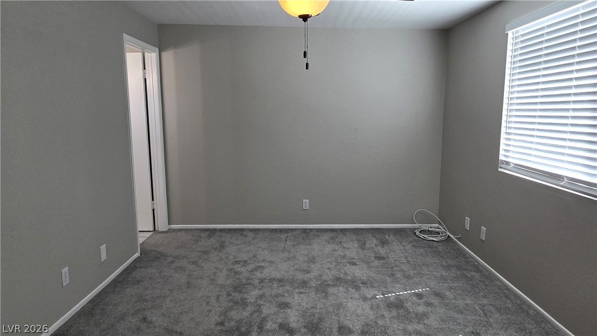 3849 Reflection Way Las Vegas, NV 89147 - Photo 20 of 25 This spacious bedroom offers ample natural light and plush carpeting, creating a comfortable retreat.