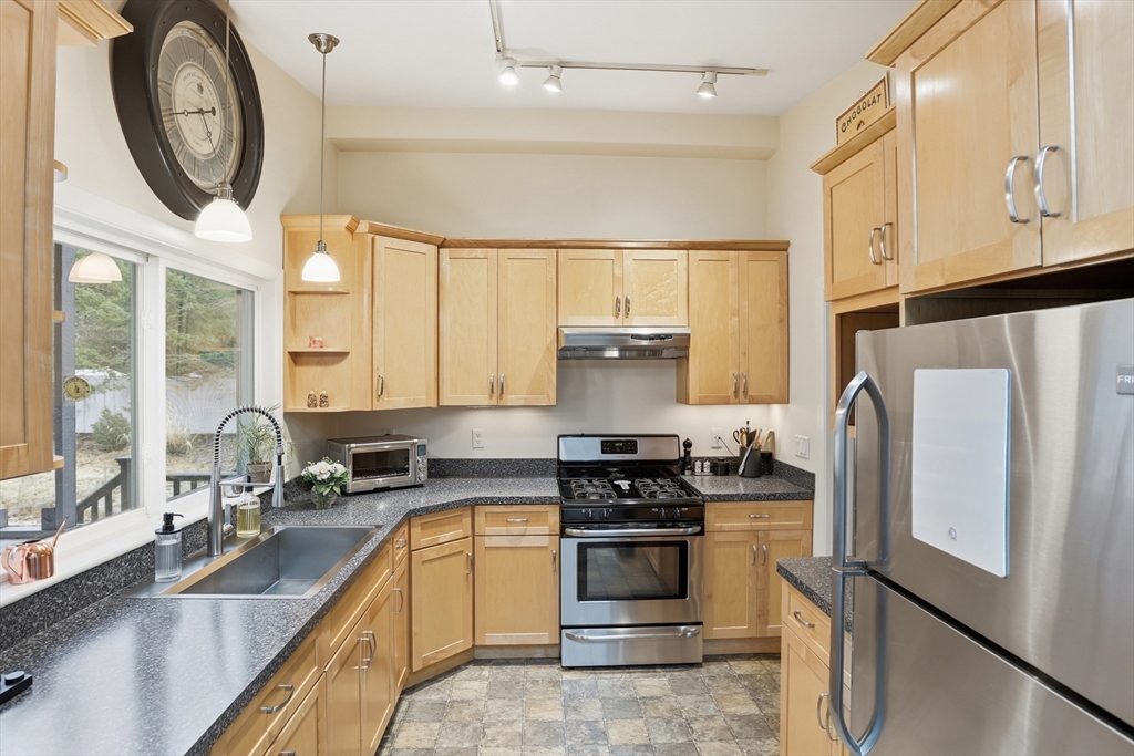 69 Robbins Road Sudbury, MA 01776 - Photo 11 of 35 a kitchen with stainless steel appliances granite countertop a refrigerator a stove and a sink with large window