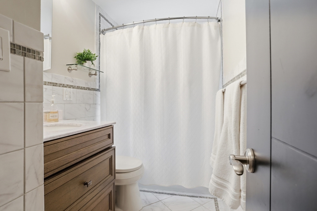 69 Robbins Road Sudbury, MA 01776 - Photo 17 of 35 a bathroom with a shower curtain and a toilet